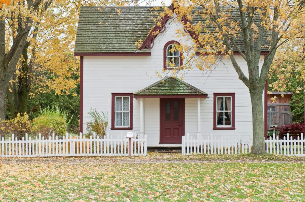 double-storey house with white picket timber fence