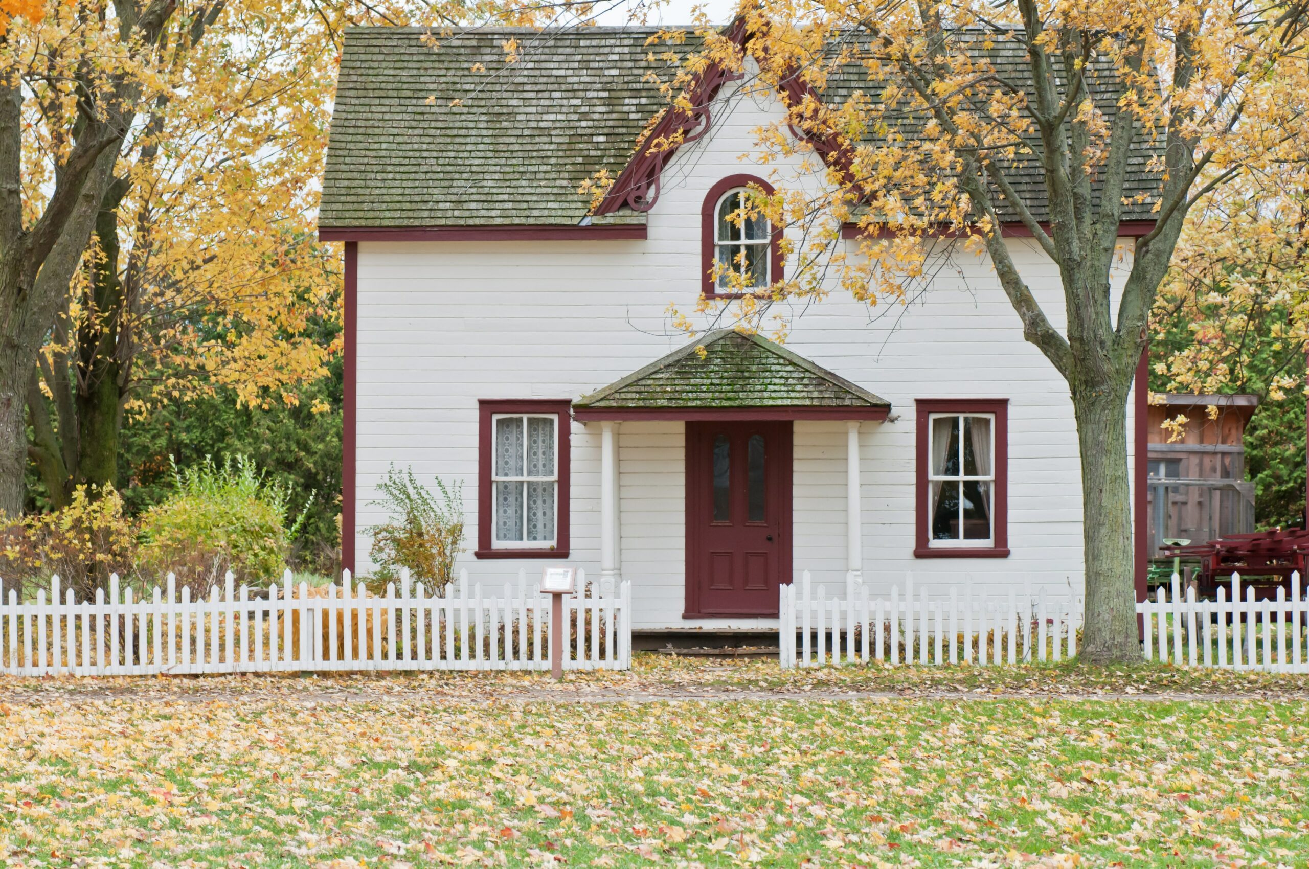 double-storey house with white picket timber fence
