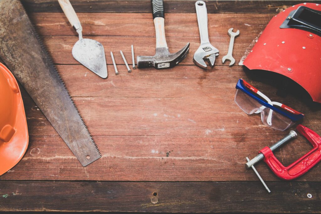 timber building tools, building supplies and building hardware on a wooden workbench.