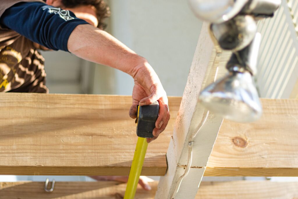 person measuring timber decking with tape measure