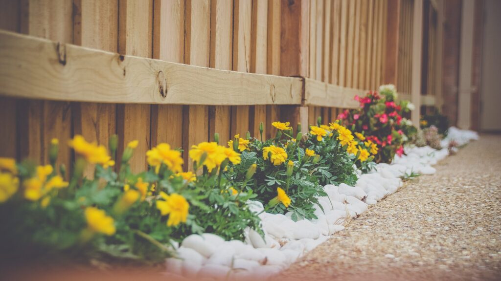 angled shot of timber fence with flower garden bed below