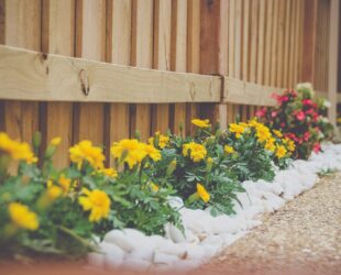 angled shot of timber fence with flower garden bed below