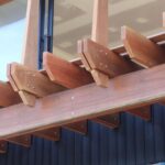 Structural timbers on a building facade installed using concealed thread bolts