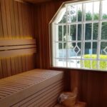 western red cedar shiplap used to clad a sauna. Both the seat and the footrest are covered in the western red cedar shiplap and there is a large white window on the far wall